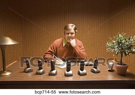 Businessman at desk with multiple telephones View Large Photo Image Stock Photography - Businessman at desk with multiple telephones. Fotosearch