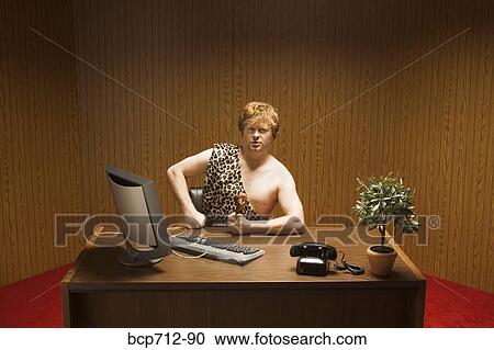 Businessman dressed as caveman at desk View Large Photo Image Stock Image - Businessman dressed as caveman at desk. Fotosearch