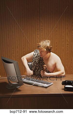 Businessman dressed as caveman at desk View Large Photo Image Stock Image - Businessman dressed as caveman at desk. Fotosearch