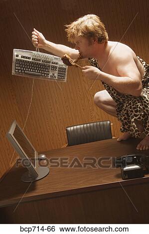 Businessman dressed as caveman crouching on desk View Large Photo Image Stock Photograph - Businessman dressed as caveman crouching on desk. Fotosearch
