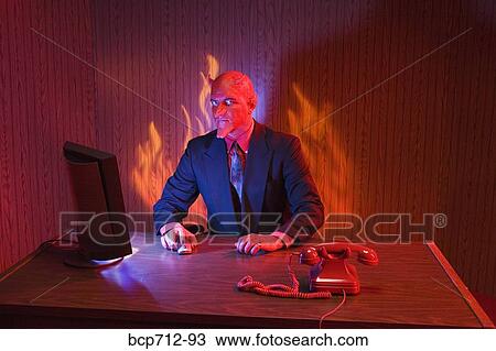 Businessman dressed as devil at desk View Large Photo Image Stock Image - Businessman dressed as devil at desk. Fotosearch