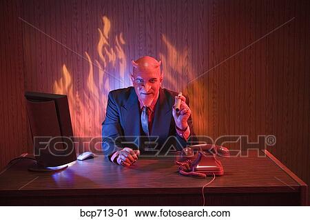 Businessman dressed as devil at desk View Large Photo Image Stock Image - Businessman dressed as devil at desk. Fotosearch