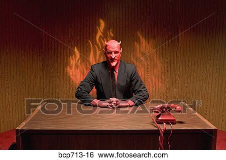 Businessman dressed as devil at desk View Large Photo Image Stock Photograph - Businessman dressed as devil at desk. Fotosearch