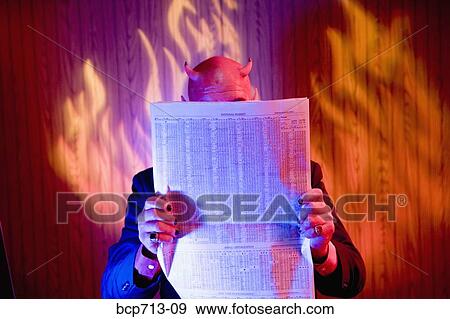 Businessman dressed as devil reading newspaper View Large Photo Image Stock Photo - Businessman dressed as devil reading newspaper. Fotosearch