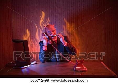 Businessman dressed as devil talking on telephone View Large Photo Image Stock Photo - Businessman dressed as devil talking on telephone. Fotosearch