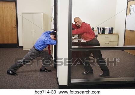 Businessman holding office door against co-worker View Large Photo Image Stock Image - Businessman holding office door against co-worker. Fotosearch