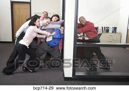 Businessman holding office door against co-workers View Large Photo Image Stock Photo - Businessman holding office door against co-workers. Fotosearch