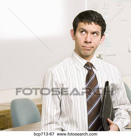 Stock Photo - Businessman thinking and holding folder. Fotosearch