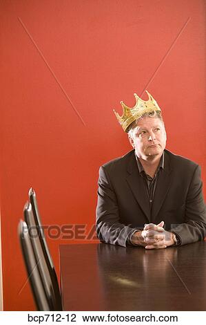 Businessman wearing gold crown in conference room View Large Photo Image Stock Image - Businessman wearing gold crown in conference room. Fotosearch