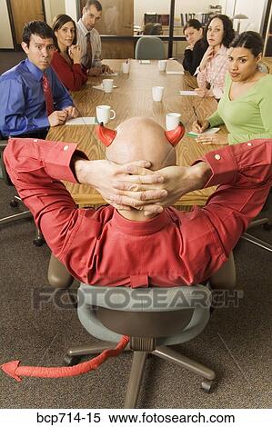 Businessman with devil horns and tail at meeting View Large Photo Image Stock Photography - Businessman with devil horns and tail at meeting. Fotosearch