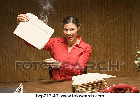 Stock Photo - Businesswoman burning files at desk. Fotosearch
