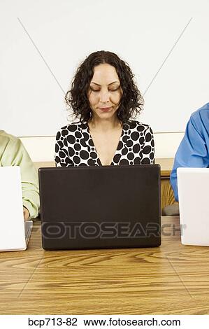 Stock Image - Businesswoman looking at laptop. Fotosearch