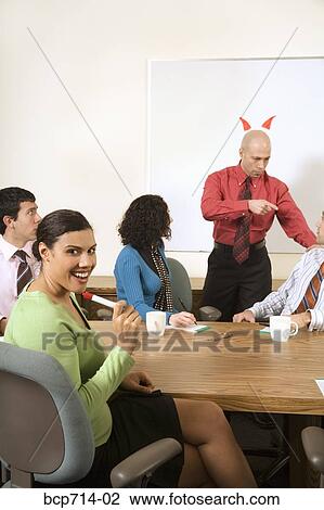 Businesswoman smiling about boss with horns over head View Large Photo Image Stock Image - Businesswoman smiling about boss with horns over head. Fotosearch