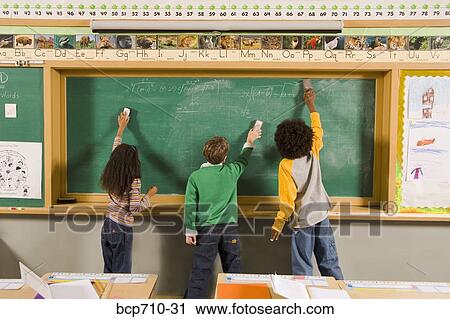 Stock Image - Children erasing blackboard in classroom. Fotosearch