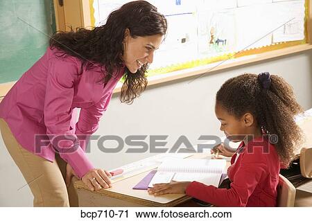 Female teacher helping student View Large Photo Image Stock Image - Female teacher helping student. Fotosearch