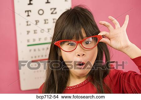 Girl wearing eyeglasses in front of eye chart View Large Photo Image Picture - Girl wearing eyeglasses in front of eye chart. Fotosearch
