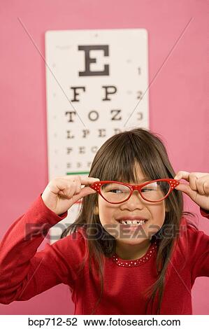 Girl wearing eyeglasses in front of eye chart View Large Photo Image Stock Image - Girl wearing eyeglasses in front of eye chart. Fotosearch