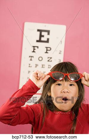 Girl wearing eyeglasses in front of eye chart View Large Photo Image Stock Image - Girl wearing eyeglasses in front of eye chart. Fotosearch