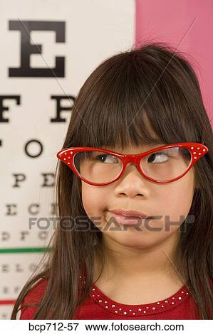Girl wearing eyeglasses in front of eye chart View Large Photo Image Stock Photo - Girl wearing eyeglasses in front of eye chart. Fotosearch