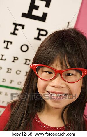 Girl wearing eyeglasses in front of eye chart View Large Photo Image Stock Photo - Girl wearing eyeglasses in front of eye chart. Fotosearch