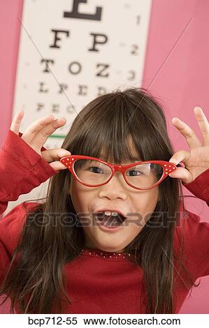 Girl wearing eyeglasses in front of eye chart View Large Photo Image Stock Photography - Girl wearing eyeglasses in front of eye chart. Fotosearch