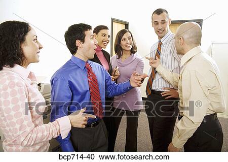 Group of co-workers talking in office View Large Photo Image Stock Image - Group of co-workers talking in office. Fotosearch