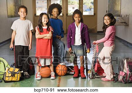 Stock Image - Group of students with sports equipment in hallway. Fotosearch