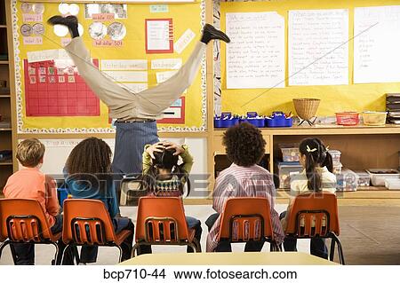 Male teacher doing handstand in classroom View Large Photo Image Picture - Male teacher doing handstand in classroom. Fotosearch