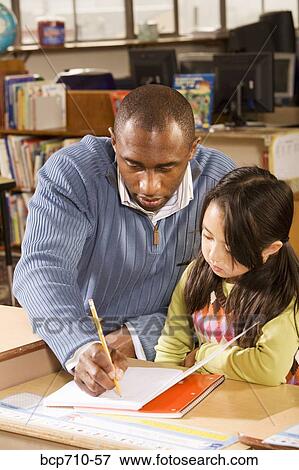 Male teacher helping student View Large Photo Image Stock Photo - Male teacher helping student. Fotosearch