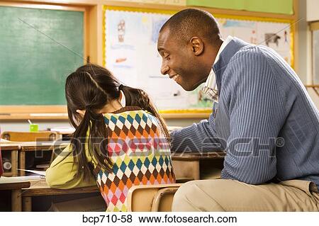 Stock Photo - Male teacher helping student. Fotosearch