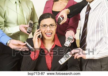 Overwhelmed businesswoman surrounded by co-workers View Large Photo Image Stock Photo - Overwhelmed businesswoman surrounded by co-workers. Fotosearch
