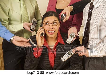Stock Photo - Overwhelmed businesswoman surrounded by co-workers. Fotosearch