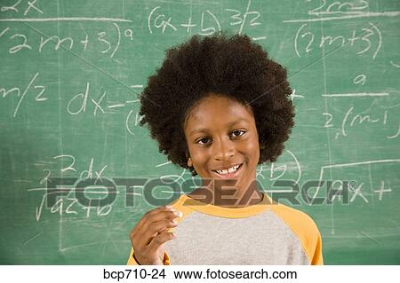 Picture - Portrait of boy in front of math on blackboard. Fotosearch