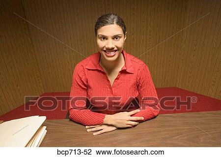 Stock Image - Portrait of businesswoman at desk. Fotosearch