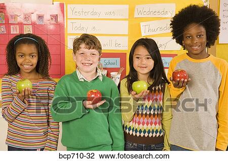 Portrait of children holding apples in classroom View Large Photo Image Stock Image - Portrait of children holding apples in classroom. Fotosearch