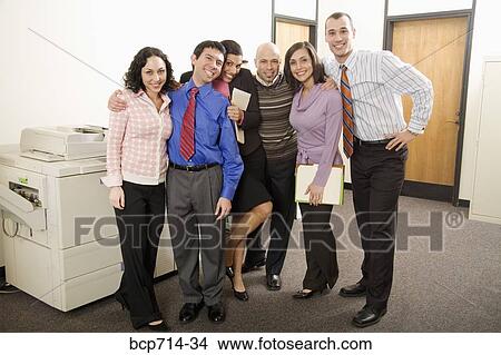 Picture - Portrait of co-workers next to photocopier machine. Fotosearch