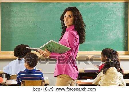 Stock Photo - Portrait of female teacher in classroom. Fotosearch
