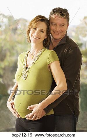 Portrait of pregnant couple hugging View Large Photo Image Stock Photo - Portrait of pregnant couple hugging. Fotosearch