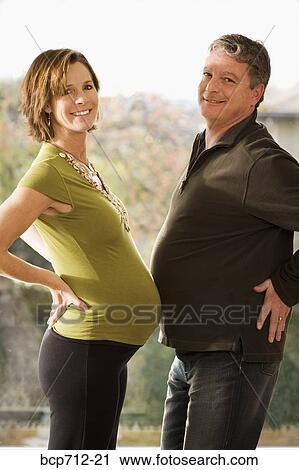Portrait of pregnant couple touching bellies View Large Photo Image Stock Image - Portrait of pregnant couple touching bellies. Fotosearch