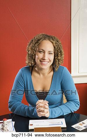 Picture - Portrait of woman at desk with mail. Fotosearch