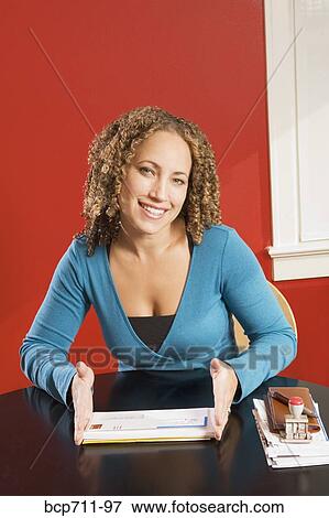 Stock Photo - Portrait of woman at desk with mail. Fotosearch
