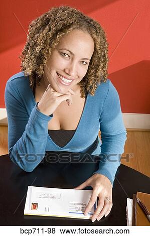 Stock Photo - Portrait of woman at desk with mail. Fotosearch