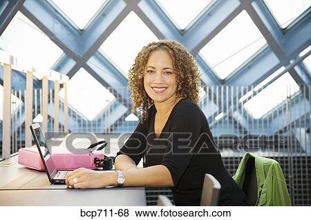 Portrait of woman sitting with laptop View Large Photo Image Stock Photo - Portrait of woman sitting with laptop. Fotosearch