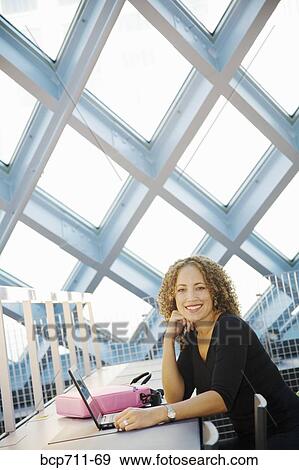 Portrait of woman sitting with laptop View Large Photo Image Stock Photo - Portrait of woman sitting with laptop. Fotosearch
