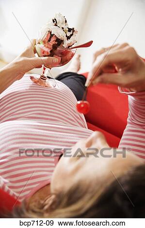 Pregnant woman eating ice cream sundae View Large Photo Image Stock Photo - Pregnant woman eating ice cream sundae. Fotosearch