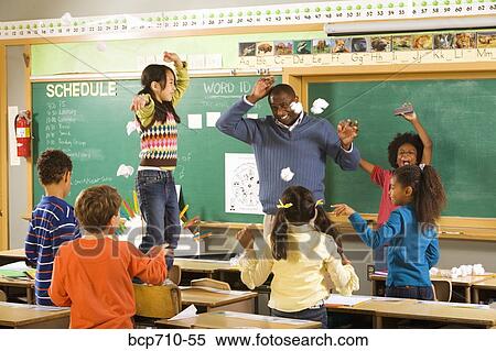 Students Having Paper Fight In Classroom Stock Photography