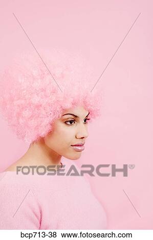 Stock Photo - Studio shot of woman wearing pink wig. Fotosearch