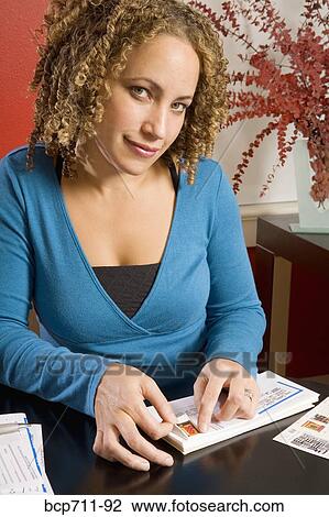 Woman affixing stamp to envelope View Large Photo Image Stock Image - Woman affixing stamp to envelope. Fotosearch