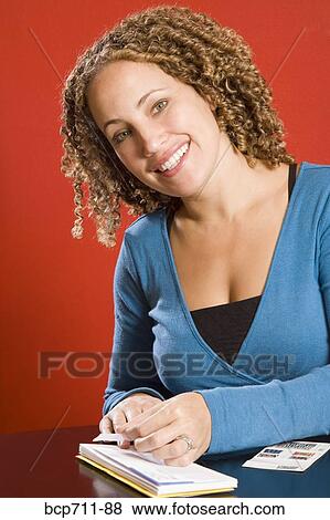 Woman affixing stamp to envelope View Large Photo Image Stock Photo - Woman affixing stamp to envelope. Fotosearch