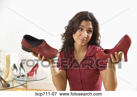 Woman comparing shoes at boutique View Large Photo Image Stock Photo - Woman comparing shoes at boutique. Fotosearch